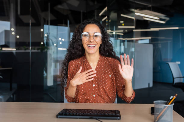 istock Online customer support video call, Latin American woman looking at web camera smiling and consulting customers, helpline worker working inside office 1456423718