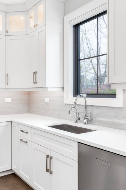 istock A kitchen detail with white cabinets, chrome faucet, and tile backsplash. 1456429606