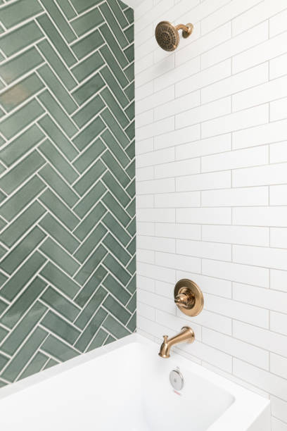 istock A shower with green herringbone and white subway tiles. 1456430133