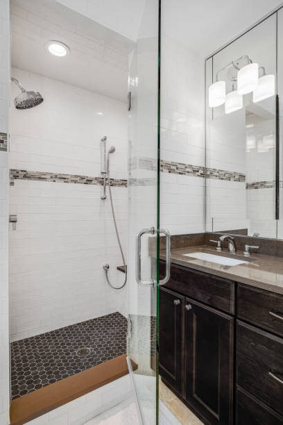 istock A bathroom with a wood cabinet and a tiled walk-in shower. 1456430177