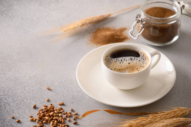 Barley coffee in white cup and ears of barley on gray background. Barley coffee in white cup, beans and ears of barley on gray background. Great warming caffeine free drink alternative coffee. Close up. decaffeinated stock pictures, royalty-free photos & images