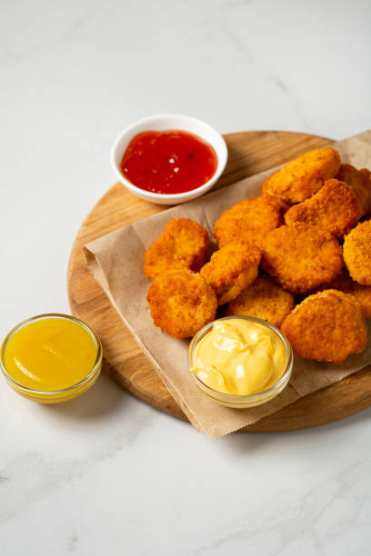 istock Close up of Chicken crunchy nuggest on plate and sauces dips 1456438123