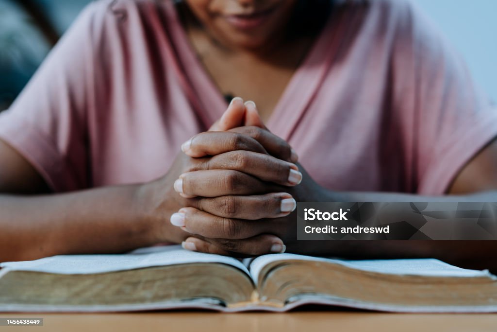 Woman praying with the bible on the table Praying Stock Photo