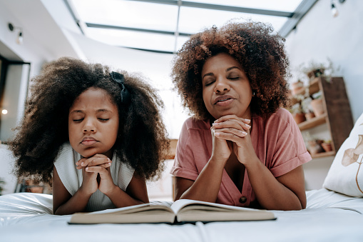 Mother teaches daughter to pray