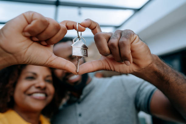 Couple second key to new home with hand in heart symbol Couple second key to new home with hand in heart symbol home ownership stock pictures, royalty-free photos & images