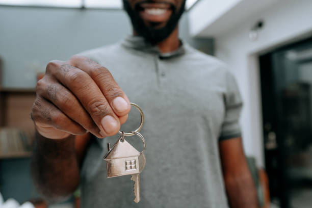 istock Man holding keys to new house 1456438591