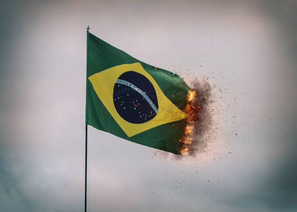 istock Brazil flag waving in a pole with fire and smoke on edges, digital composite 1456447533