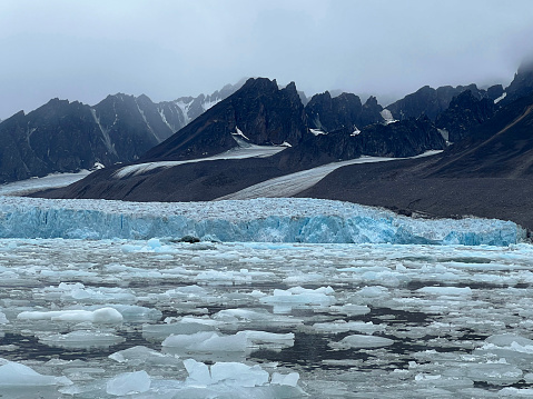 visitors to Svalbard view glaciers from zodiacs and witness a calving event.