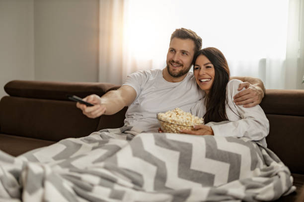 istock Young couple watching TV at home 1456450362