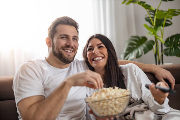 istock Young couple watching TV at home 1456450471