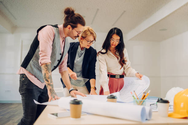 istock Multiracial team of architects having a meeting while using blueprints 1456452943