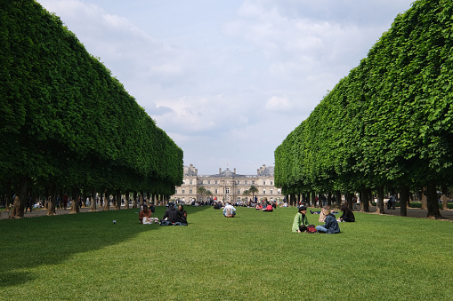 Paris, France - May, 2022: Tourists and Parisians relaxing in Luxembourg Garden. Jardin du Luxembourg - second largest Public Park in Paris. Park is garden of French Senate
