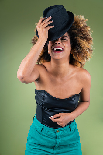 Portrait of carefree childish person show tongue fingers demonstrate heavy metal symbol isolated on green color background.