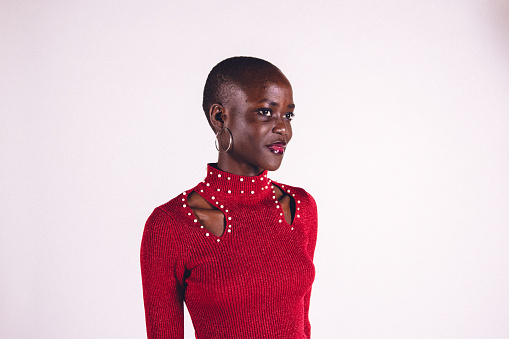 Young African American studio portraiture in red dress over a white background.
