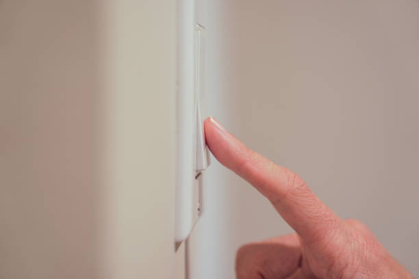 istock Closeup of female finger pushing light switch 1456465709