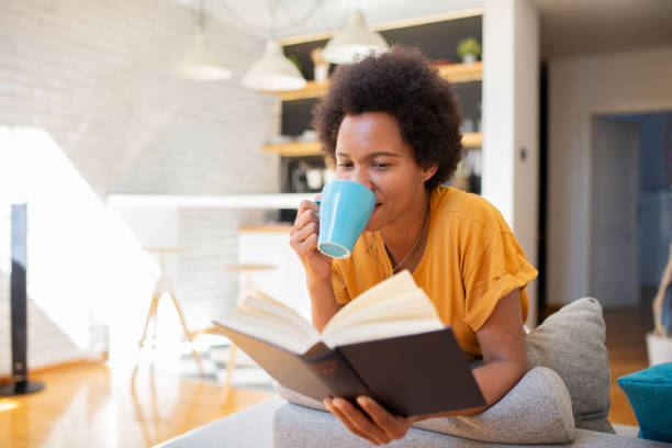 istock Happy woman reading book at home 1456466695