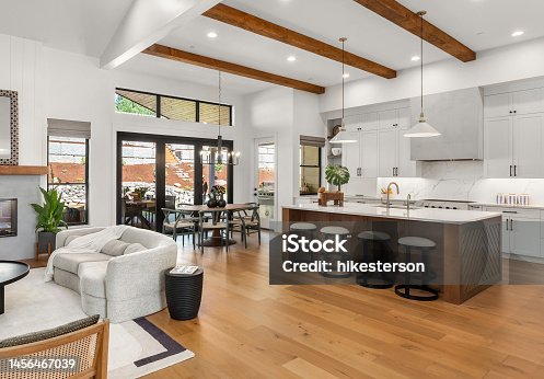 istock Beautiful living room and kitchen in new luxury home with white cabinets, wood beams, pendant lights and hardwood floors 1456467039