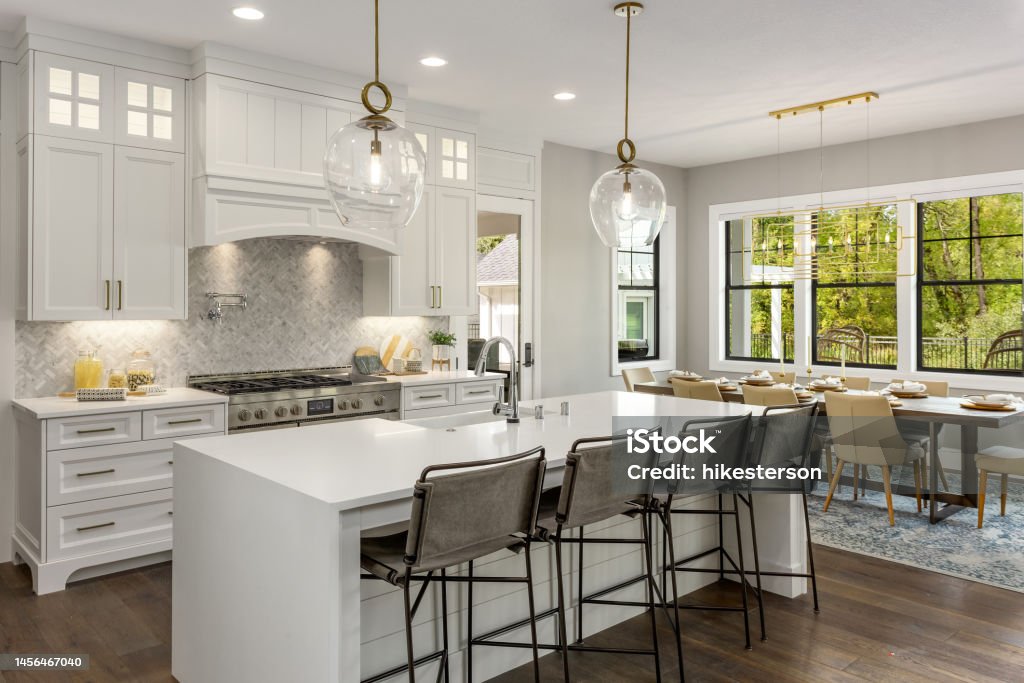 beautiful kitchen in new luxury home with island, pendant lights, and hardwood floors. kitchen in newly constructed luxury home Kitchen Stock Photo