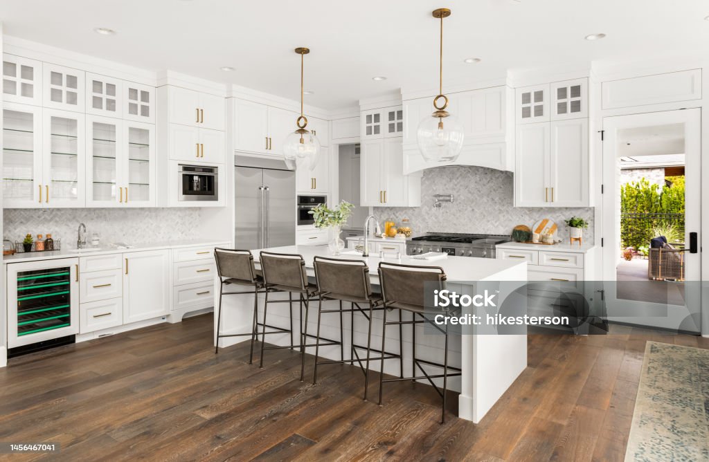 Beautiful kitchen in new farmhouse style luxury home with island, pendant lights, and hardwood floors. kitchen in newly constructed luxury home Kitchen Stock Photo