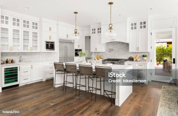Beautiful Kitchen In New Farmhouse Style Luxury Home With Island Pendant Lights And Hardwood Floors Stock Photo - Download Image Now