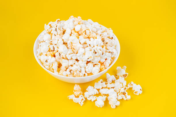 istock Scattered tasty cheese popcorn in bowl isolated on yellow background 1456473395