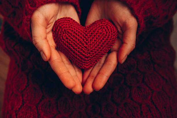 istock Female hand holding red knitted heart 1456473422
