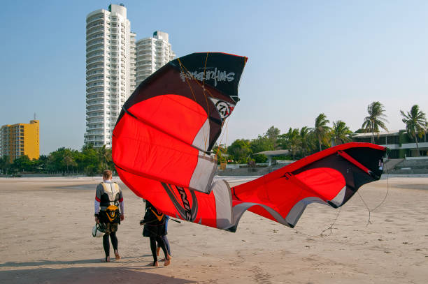 hua hin thailand may 4 2006 -two unknown man carrying his kite sail on the beach in hua hin in thailand