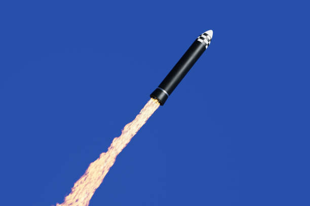 istock Rocket missile with a long jet of fire propulsion is being launched into the blue sky. Illustration of the concept of development of satellites or nuclear warheads 1456478392