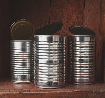 Empty tin cans on rustic wood shelf