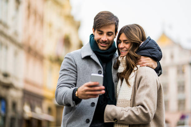 Young couple using smart phone in the city. stock photo