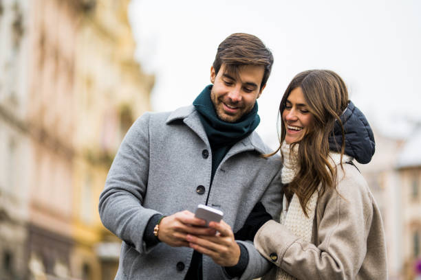 istock Young couple using smart phone in the city. 1456483742
