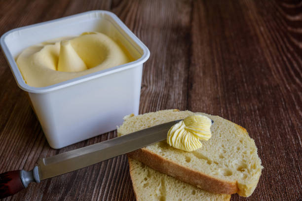 istock Slice of bread spread with creamy butter. 1456488796
