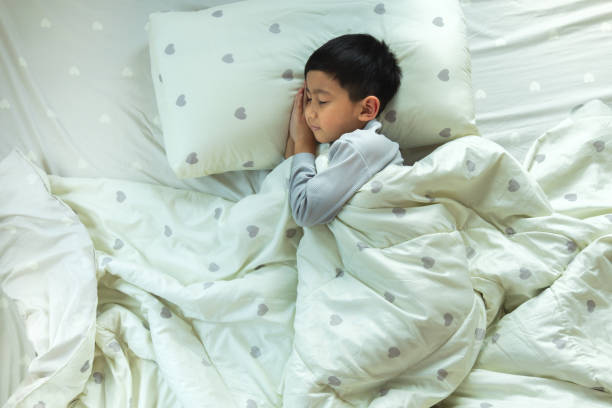 istock Top View of Asian boy having sweet dreams while Sleeping Cozily Bed 1456489032