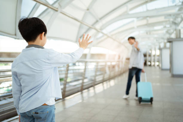 asian man and little boy traveling together in city. - separation airport child waving imagens e fotografias de stock