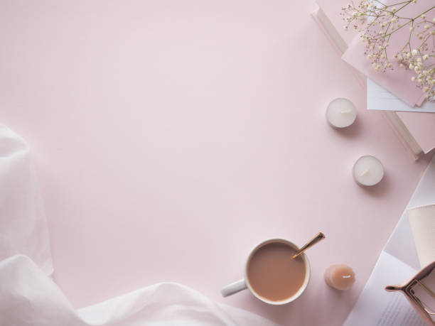 istock Feminine, cute desk frame with small items arranged on a light pink background, text space 1456496025