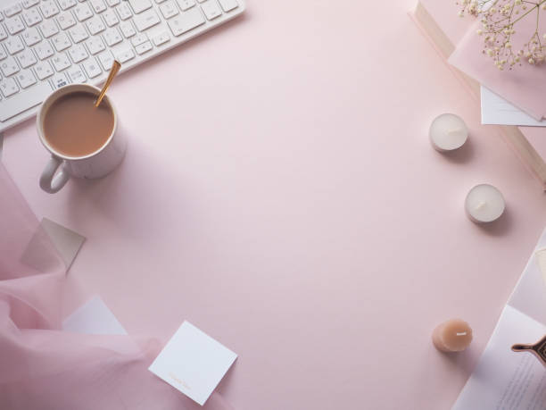 istock Feminine, cute PC desk frame with small items arranged on a pale pink background, text space 1456496026