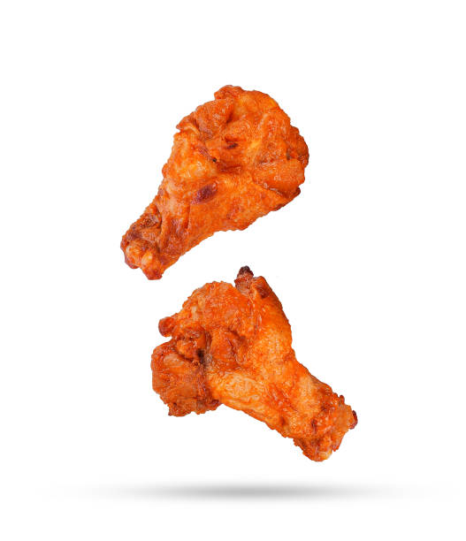 istock Barbecue chicken legs falling in the air isolated on white 1456497147