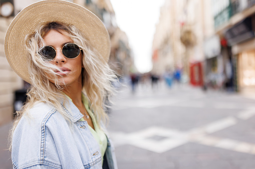 Close-up shot of beautiful young woman with sunglasses walking in the city