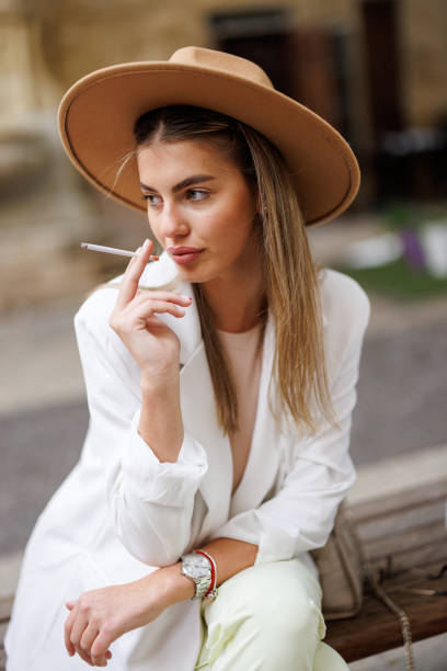istock Young woman smoking cigarette outdoors 1456500228