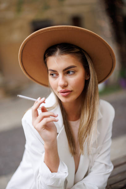 istock Young woman smoking cigarette outdoors 1456500447