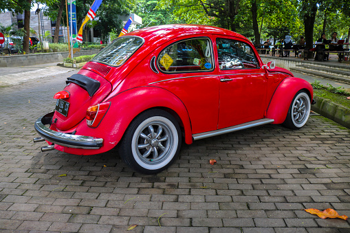 Yogyakarta, Indonesia - January 12, 2023: 1974s vintage VW Beetle 1303 car parked in a city park. Side view of vintage car