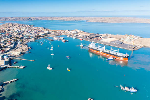 Freight vessel against backdrop of Luderitz, Namibia, medium wide