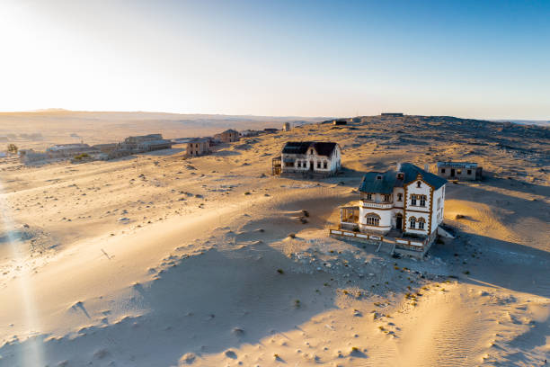 Dawn over historic Kolmanskop village in Namibia Deserted homes in Kolmanskop ghost town near Luderitz in Namibia, the site of an abandoned diamond mine abandoned place stock pictures, royalty-free photos & images
