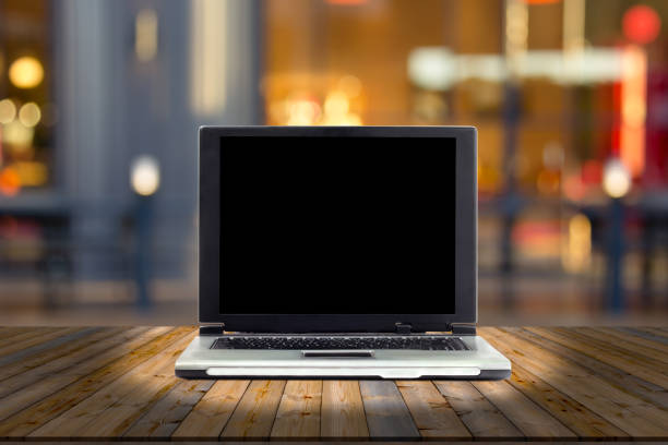 istock laptops on desk with blur restaurant background,top wooden table 1456506879