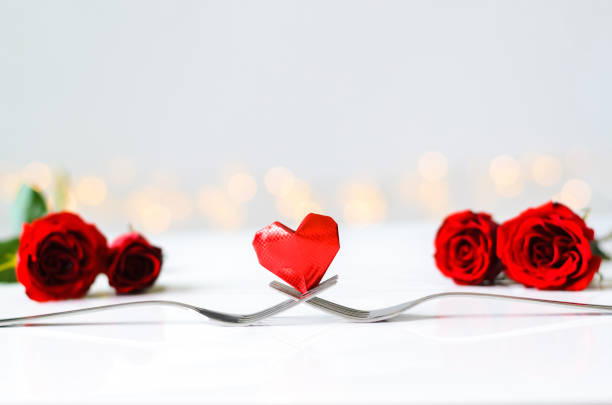 istock Red heart shape paper fold put on two forks with roses 1456509470