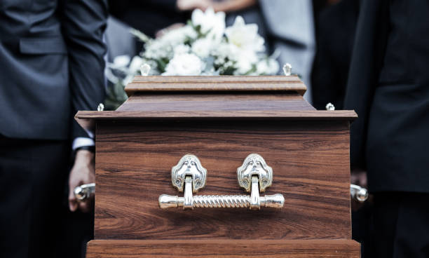 Coffin, people and funeral with death, grief and service with family carry casket to grave outdoor. Rip, farewell and ceremony or event for dead person together in respect, religion and spiritual stock photo