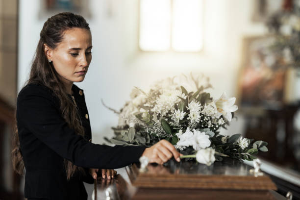 funeral, sad and woman with flower on coffin after loss of a loved one, family or friend. grief, death and young female putting a rose on casket in church with sadness, depression and mourning - pijn fotos stockfoto's en -beelden