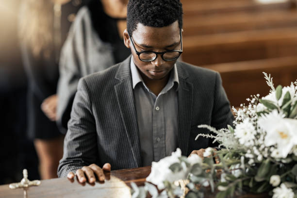 cercueil funéraire, mort et homme noir triste, deuil et deuil perte de famille, d’amis ou d’un être cher décédé. service religieux, fleurs florales et personne avec cercueil, chagrin et tristesse pour la perte de la vie - funérailles photos et images de collection