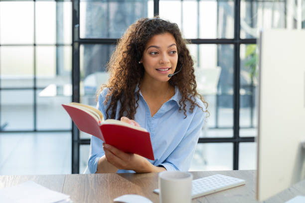 istock Beautiful smiling call center worker in headphones is working at modern office 1456514950