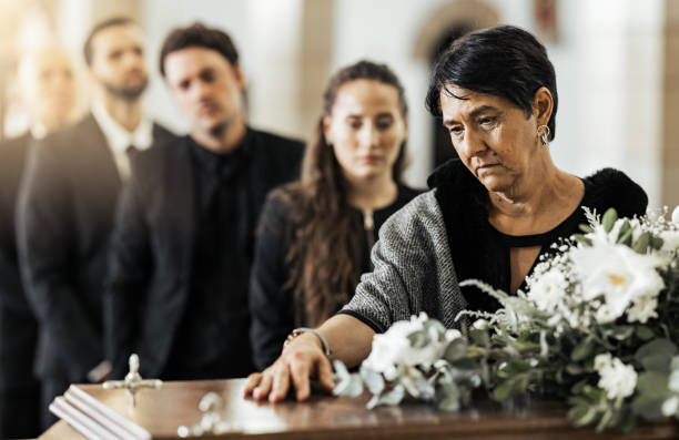 funeral, death and coffin in church or christian family gathering together for support. religion, sad people and mourning loss or religious catholic men and women grief in church service over casket - funeral family sadness depression imagens e fotografias de stock